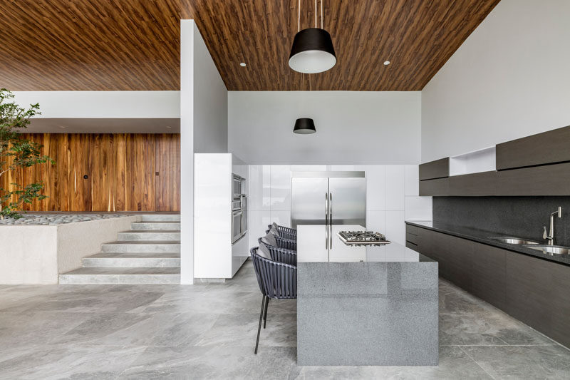 Minimalist kitchen cabinets creates a streamlined and modern appearance for this modern kitchn, while a large island provides additional space for storage and seating. #ModernKitchen #MinimalistKitchen #KitchenDesign