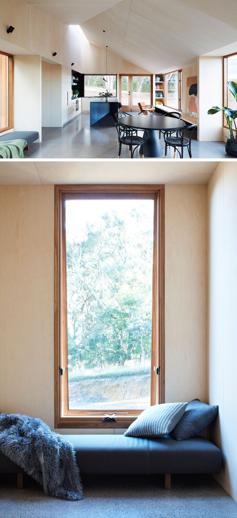 Separating the living room and the kitchen in this modern house, is a dining area furnished with a matte black, round dining table and chairs. Next the dining area is a tall window with a bench, that creates a space for someone to gaze at the surrounding nature. #BlackDiningTable #WindowSeat #Windows