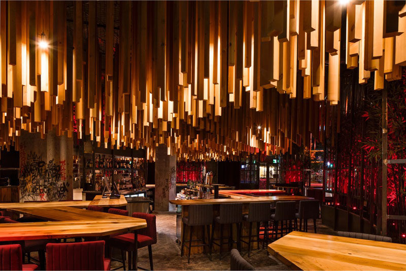 Design firm Jean de Lessard - Designers Créatifs have recently completed Ganadara, a new restaurant in Montreal, Canada, that features 2,700 wood lengths that hang from the ceiling. #RestaurantDesign #Wood #WoodCeiling #ModernRestaurant