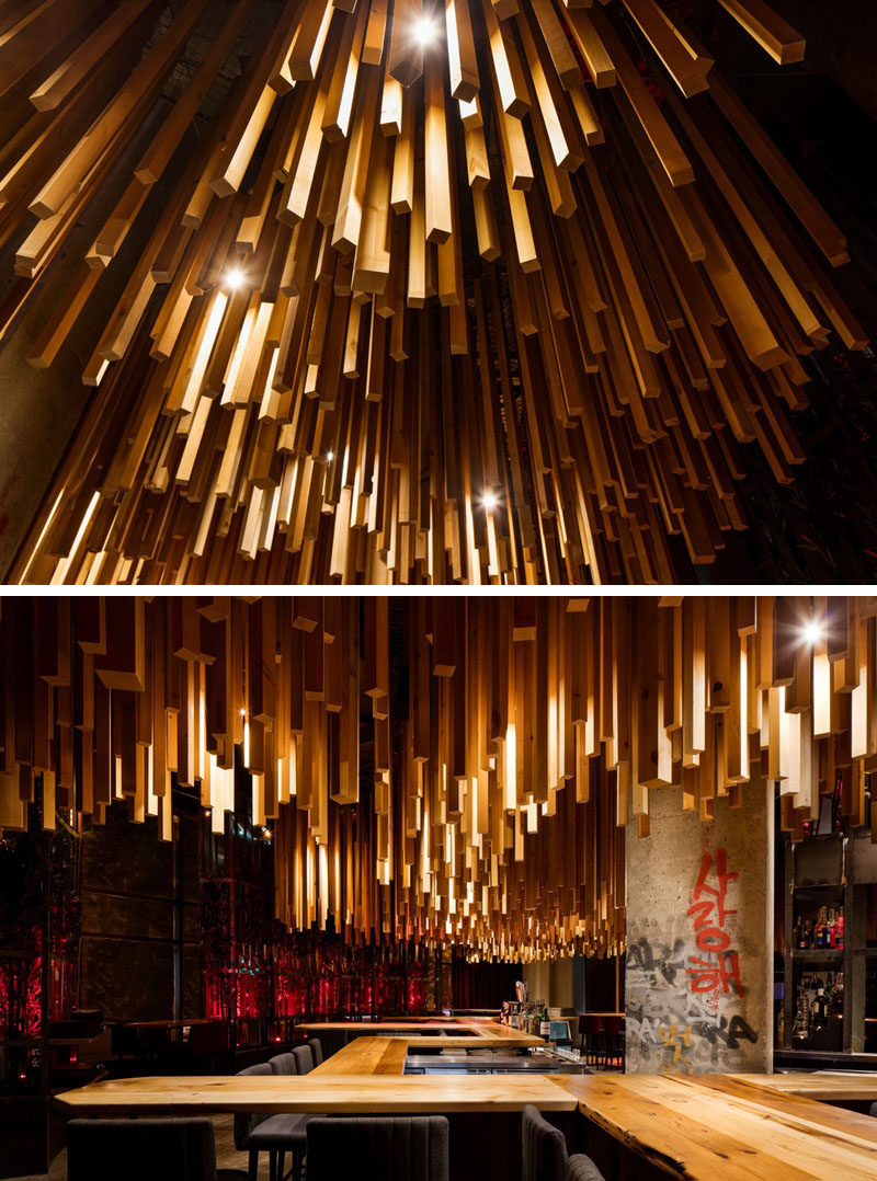 Design firm Jean de Lessard - Designers Créatifs have recently completed Ganadara, a new restaurant in Montreal, Canada, that features 2,700 wood lengths that hang from the ceiling. #RestaurantDesign #Wood #WoodCeiling #ModernRestaurant