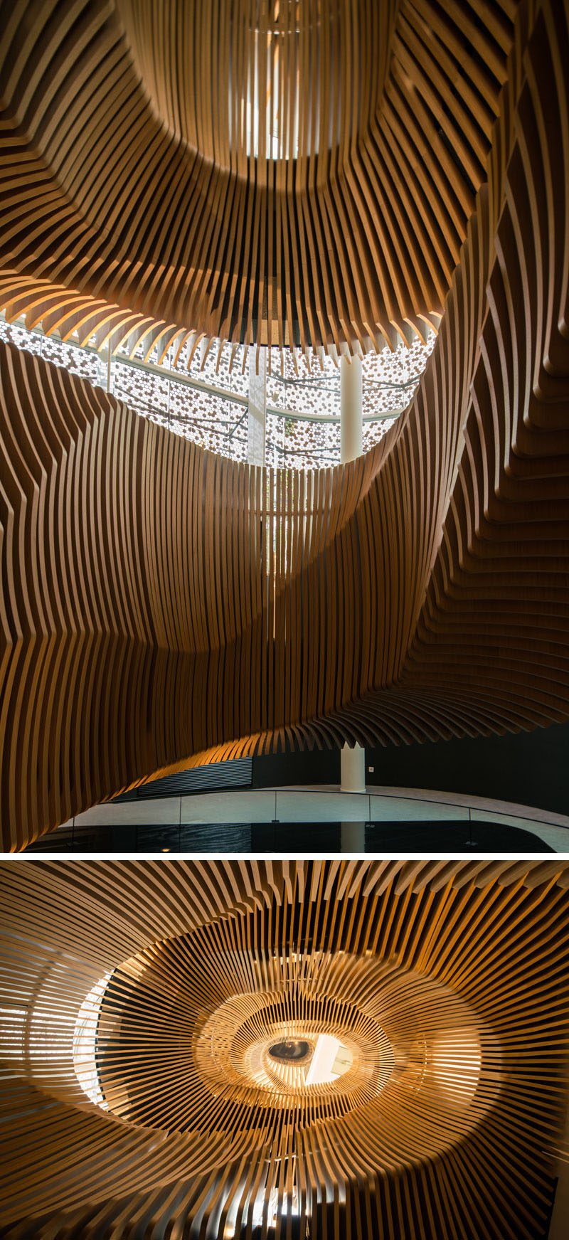 This large, sculptural, snake-like, wood staircase was installed in a new office building in France to connect the four floors of the building. #WoodStairs #SculpturalStairs #StairDesign #OfficeDesign #Stairs