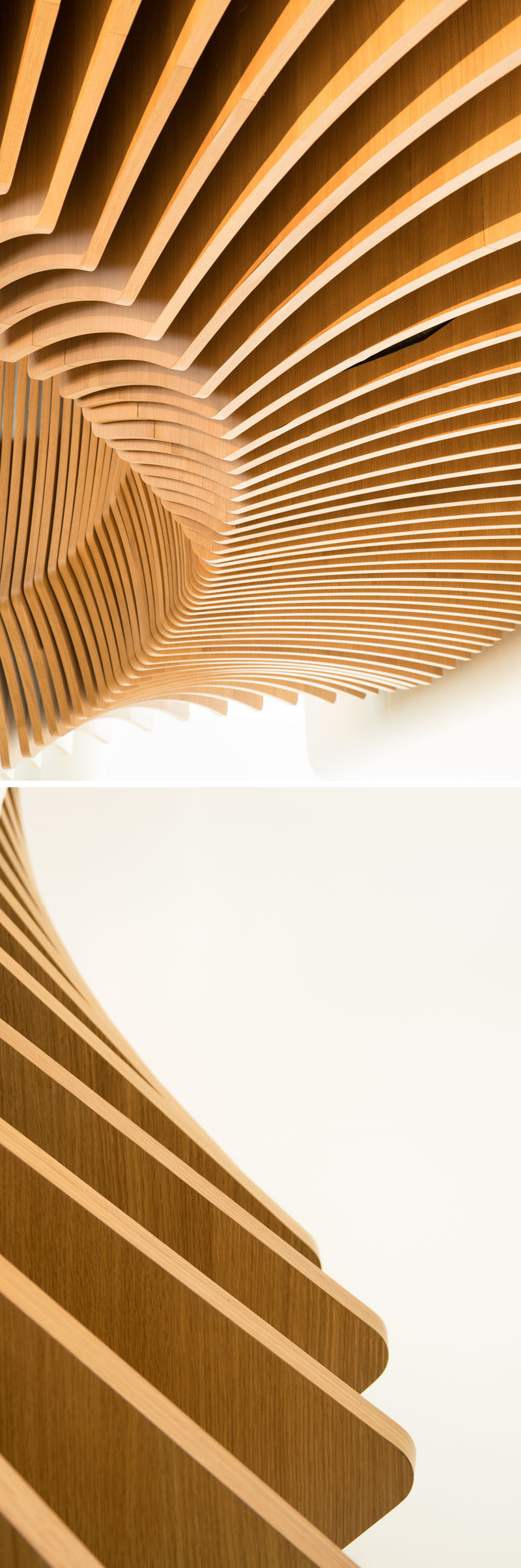 This large, sculptural, snake-like, wood staircase was installed in a new office building in France to connect the four floors of the building. #WoodStairs #SculpturalStairs #StairDesign #OfficeDesign #Stairs
