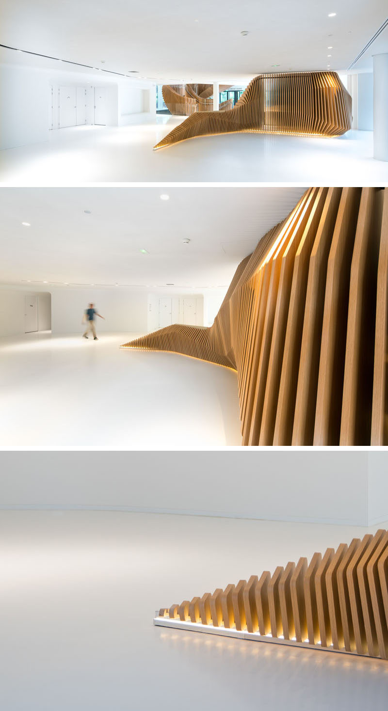 This large, sculptural, snake-like, wood staircase was installed in a new office building in France to connect the four floors of the building. #WoodStairs #SculpturalStairs #StairDesign #OfficeDesign #Stairs