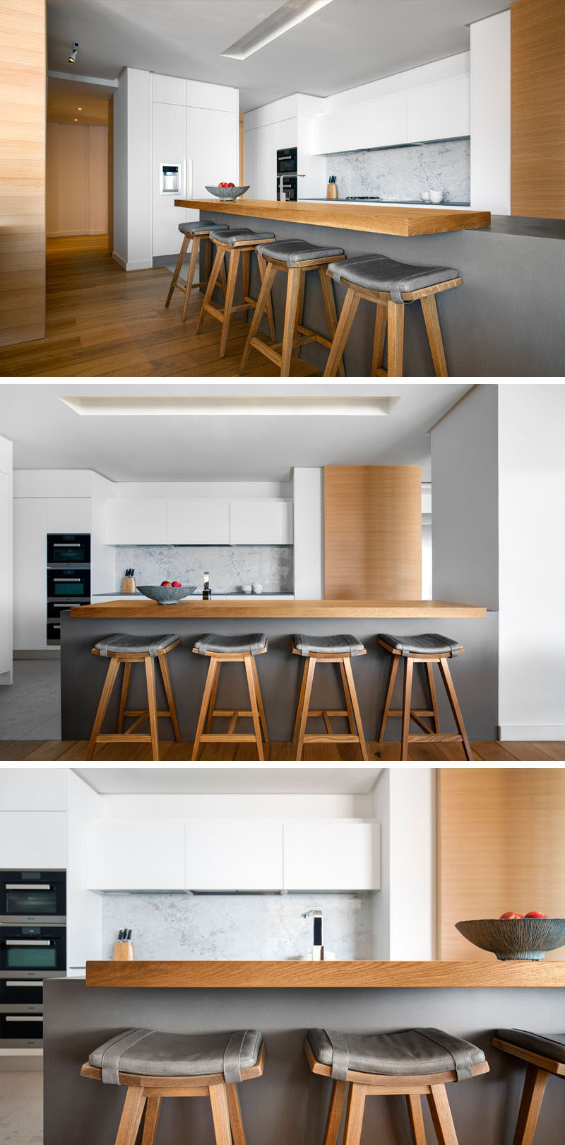 This modern kitchen features a central island in the form of a grey, neolith block with a floating timber bar countertop, accompanied by leather cushioned barstools, that add a sense of masculinity to the space. #ModernKitchen #KitchenDesign #InteriorDesign #GreyAndWhiteKitchen