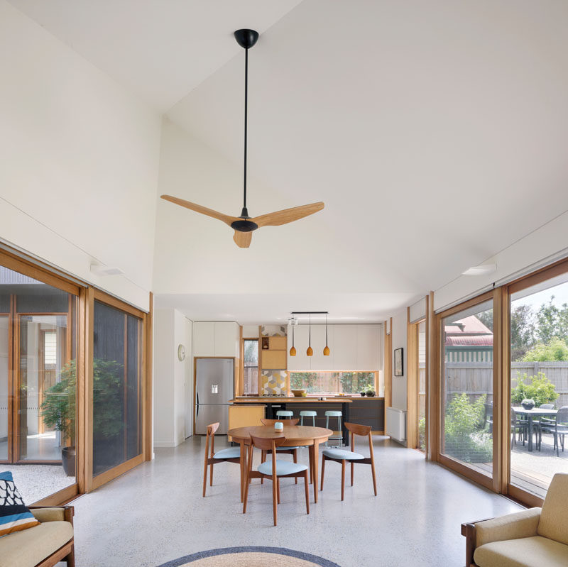 In this dining area, it's easy to see how open the house is, with sliding doors on either side that open to the courtyard and the backyard. #ModernHouse #OpenPlanLiving #HighCeilings