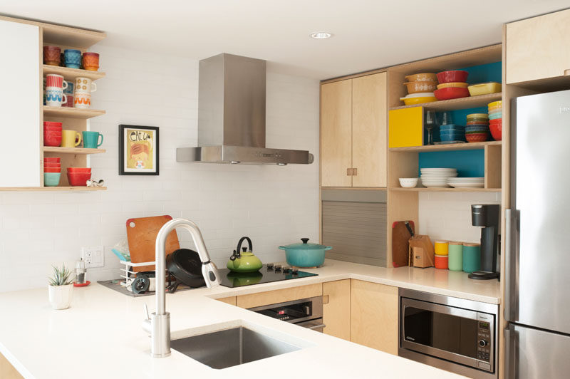 This kitchen has open shelving that allows the collections of colorful vintage cookware to be on display. #OpenShelving #PlywoodKitchen #KitchenDesign