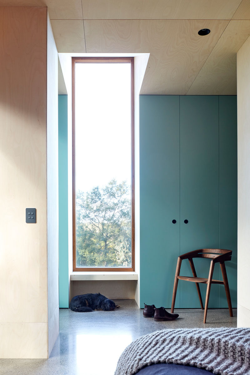 A pop of color has been added to this modern bedroom by the use of light blue, floor to ceiling cabinets. #Blue #Storage #Windows #Bedroom