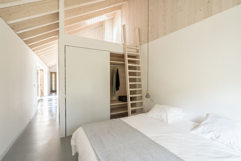 Due to the generous height of the ceilings in this contemporary stone cottage, a mezzanine is located on top of the bathroom core to allows for additional sleeping areas that are suitable for a couple or children. #Mezzanine #StoneCottage #BedroomDesign