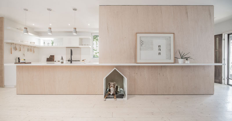 When Studio AC were designing the renovation of a house in Toronto, they made sure to include a design element for the family pup, that consists of a little white dog house built-into the surrounding plywood design element. #DogHouse #BuiltInDogHouse #DogBed #InteriorDesign