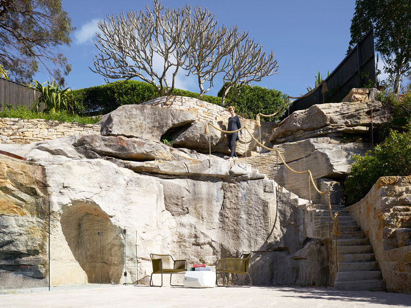 In this backyard, a pre-existing Frangipani tree is located at the top of the cliff, so a stonemason cut a staircase into the rock to connect the terrace with the top of the garden. #Landscaping #Stone #Patio