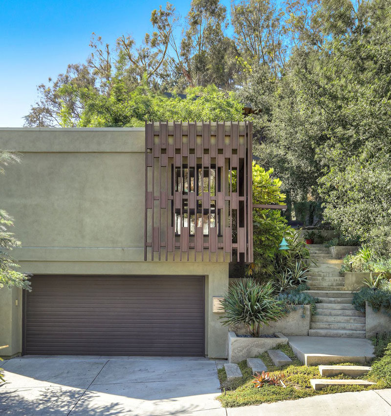 Architect Glen Bell of DEX Studio, has designed the contemporary renovation of a house and its guest house in Los Angeles, California, that sits on a hill and features custom iron and steel work. #Garage #Landscaping #Architecture