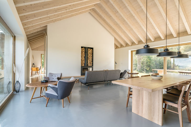 The interior of this contemporary stone cottage has plenty of wood elements to give a warm feeling, while a combination of classic sitting furniture, minimalist elements and a fireplace create a very calm and relaxing space. #StoneCottage #ContemporaryInterior #WhiteWalls #WoodCeiling #Fireplace