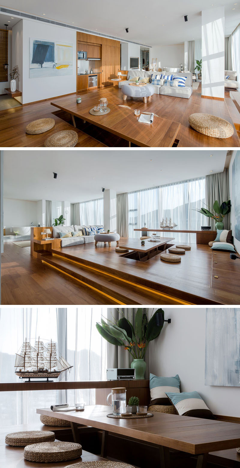 This modern and open plan apartment has a tea area, where a section of the floor is raised to create a table with a hollow space underneath for placing your legs when sitting, while round straw cushions make it comfortable to sit at. #TeaRoom #LivingRoom #ApartmentDesign #InteriorDesign