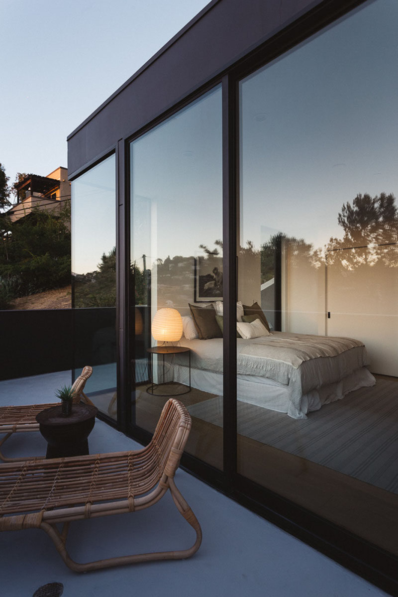 Tall floor-to-ceiling windows provide ample light to the master bedroom inside. #Windows
