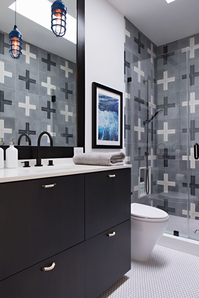 In this modern kids bathroom, fun tiles with a plus pattern have been used in the shower, while a built-in shower shelf is at the perfect height for little kids. The black vanity, faucet and mirror frame compliment the black in the tiles. #KidsBathroom #ModernBathroom