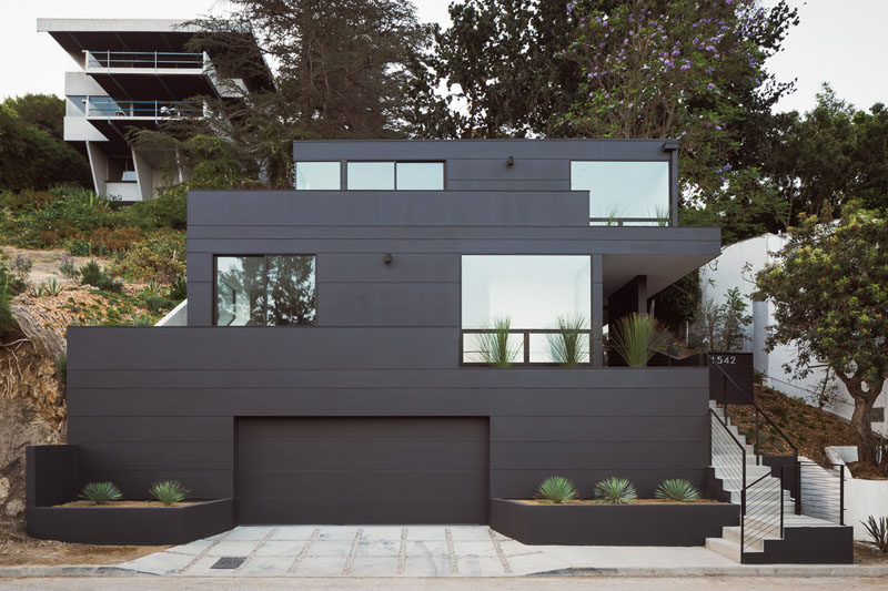 Aaron Neubert Architects have designed the Tilt-Shift House, a modern house that has a striking, bold black exterior and sits on a steep slope in the hills of Los Angeles. #BlackHouse #ModernHouse #Architecture