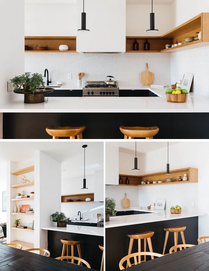 The upper half of this modern kitchen is kept bright with the use of white walls and wood shelving. The lower half with the cabinetry is matte black, creating a strong contrast to the rest of the kitchen. #ModernKitchen #BlackAndWhite #KitchenDesign