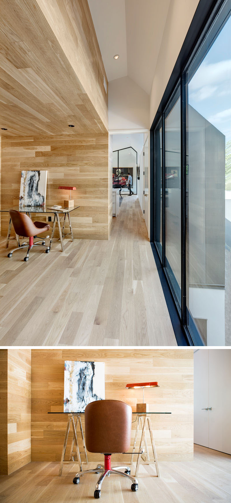 This modern house has a small hallway that leads to a home office nook surrounded by wood. #HomeOffice #OfficeNook #InteriorDesign