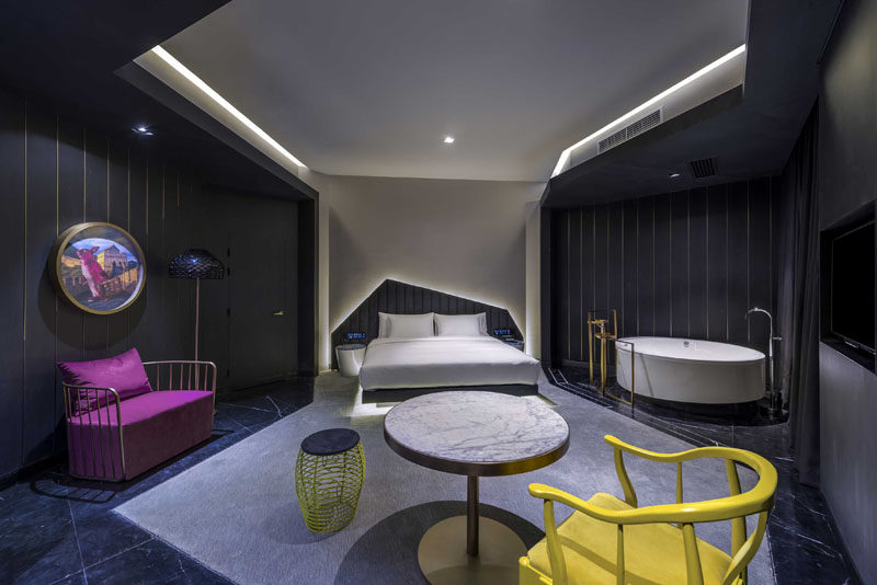 In this modern hotel room, the dark areas define a sitting area and a open bathing area, while the lighter grey defines the bed with a backlit headboard. #HotelRoom #HiddenLighting #HotelDesign