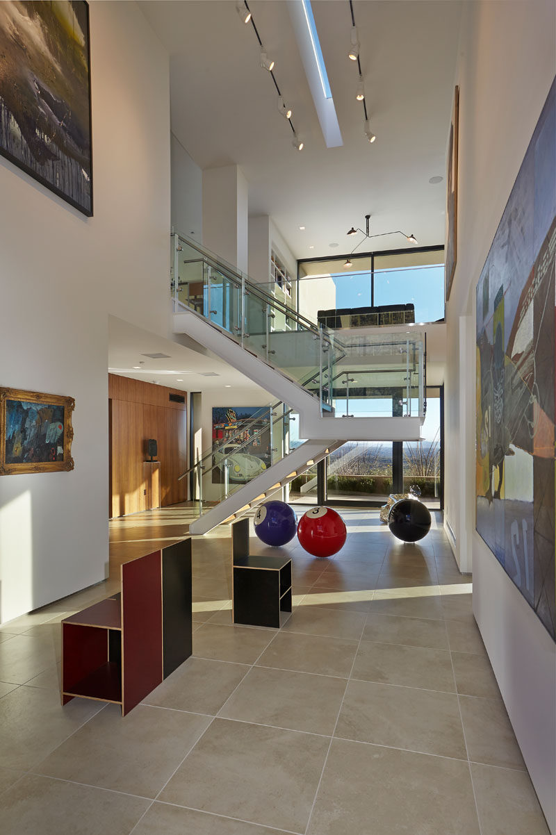 In this modern house, a double height space has been dedicated to being a private art gallery, with art pieces hanging on the walls and sculptures on the floor. #ArtGallery #ModernHouse