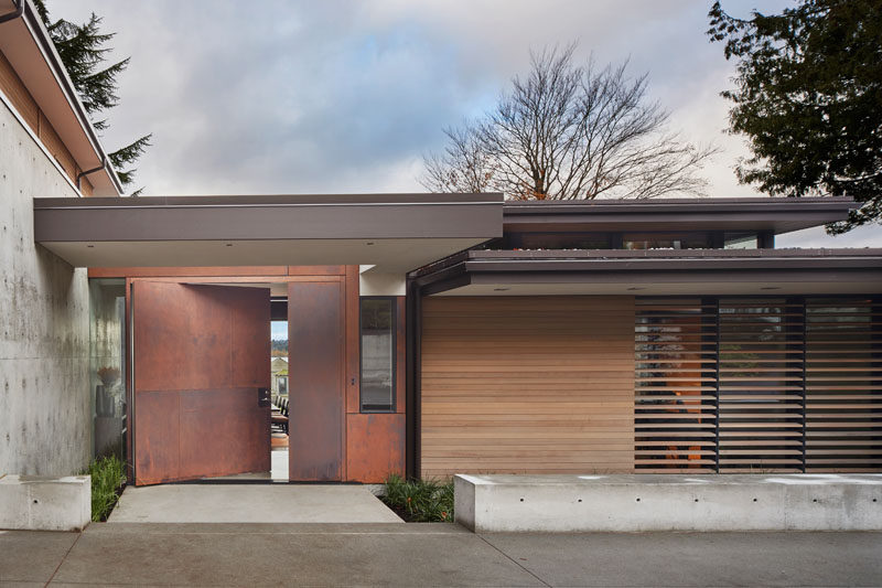 This modern house has a large, pivoting steel front door. #PivotingDoor #ModernHouse #FrontDoor