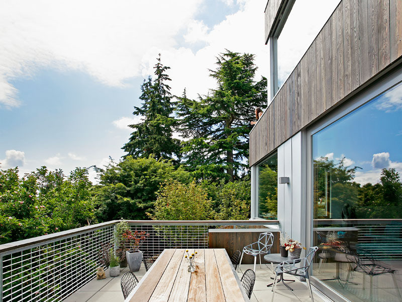 This modern house has a deck off the main living area, that provides views of the surrounding neighborhood. #Deck #ModernHouse