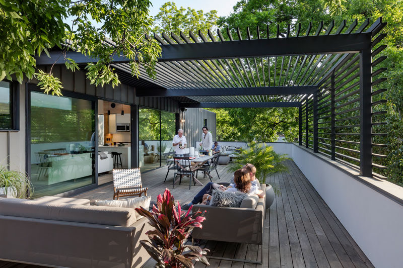 Custom-made steel and glass sliding doors open the living space of this modern house to a large roof terrace creates an indoor/outdoor living environment. #RoofTerrace #ModernPergola #OutdoorSpace