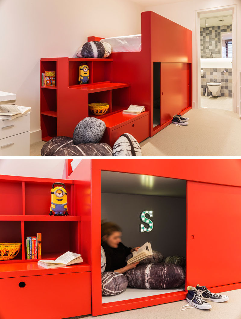 In this modern kids bedroom, a custom-designed, bright red bed unit was created with storage shelves, that double as stairs to the bed. Underneath the bed, there's a small den with sliding doors, creating a quiet reading nook. #KidsBedroom #BedroomDesign #TweenBedroom