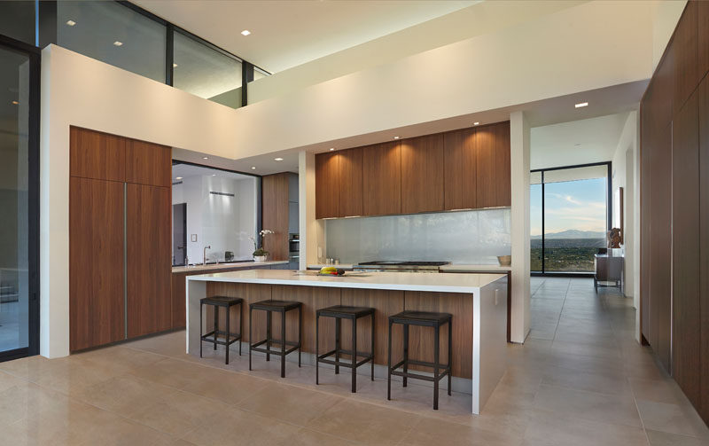 In this modern kitchen, wood cabinetry adds warmth to the space and a large island provides space for people to sit and relax. #ModernKitchen #KitchenDesign