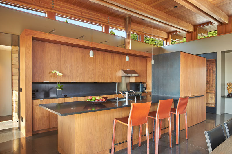 In this modern kitchen, simple wood cabinets are combined with a grey counter to create a contemporary appearance. #WoodKitchen #KitchenDesign