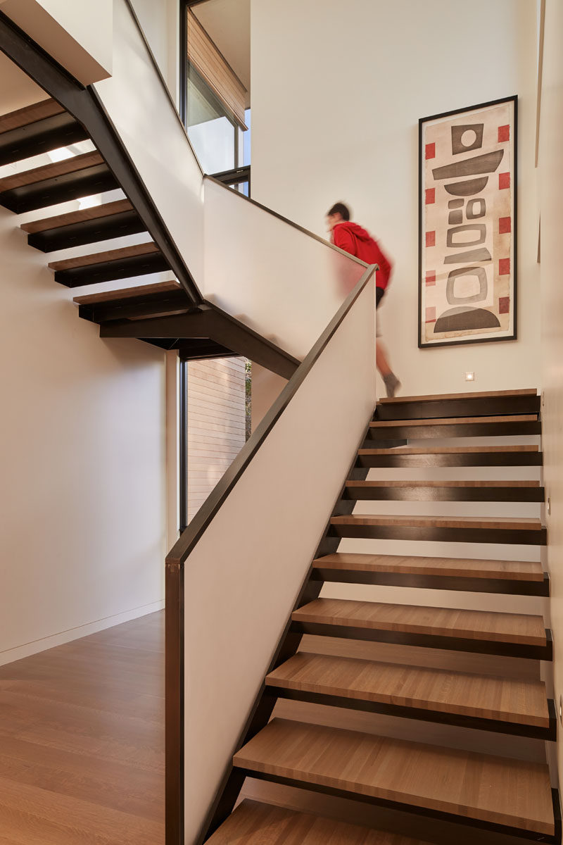 These modern stairs with wood treads features a frosted handrail. #Stairs #StairDesign