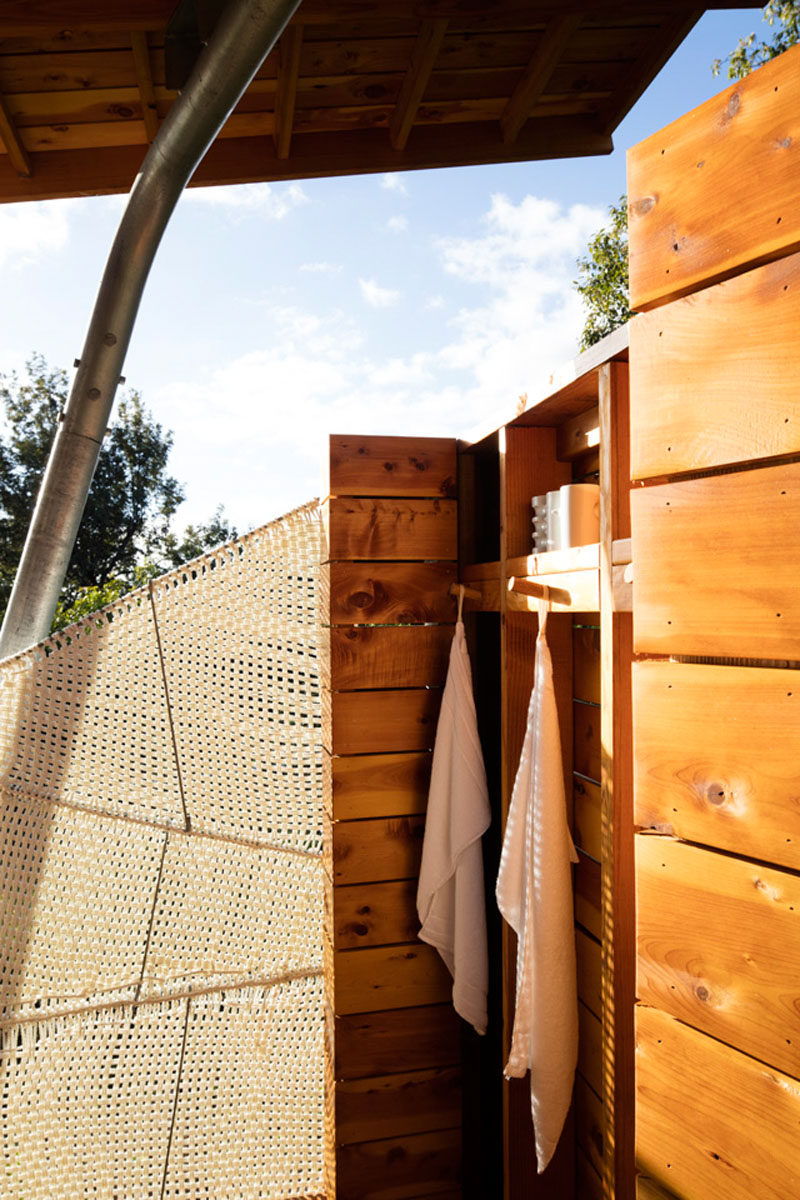 This modern outdoor pavilion has an open shower, with some privacy provided by a woven marine rope shaded panel that was created by the designer of the project. #WovenScreen #OutdoorShower