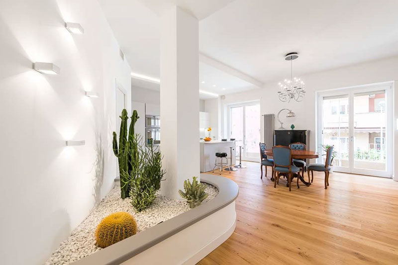 To work with an awkward column, the designers of this interior built a planter with a bench that incorporates the column, and draws the eye to the lighting and plants, helping the column to 'disappear' and blend into its surroundings. #Column #InteriorDesign #Planter #BuiltInPlanter