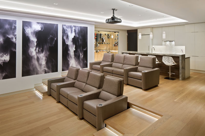 This basement is home to a theater room with tiered seating and a bar with built-in wine cellar. #HomeTheater #Basement