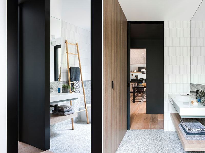 In this modern bathroom, a large floor-to-ceiling wood cabinet adds a natural touch to the space and ties in with the floating wood shelf under the vanity. #ModernBathroom #WoodCloset #BathroomDesign