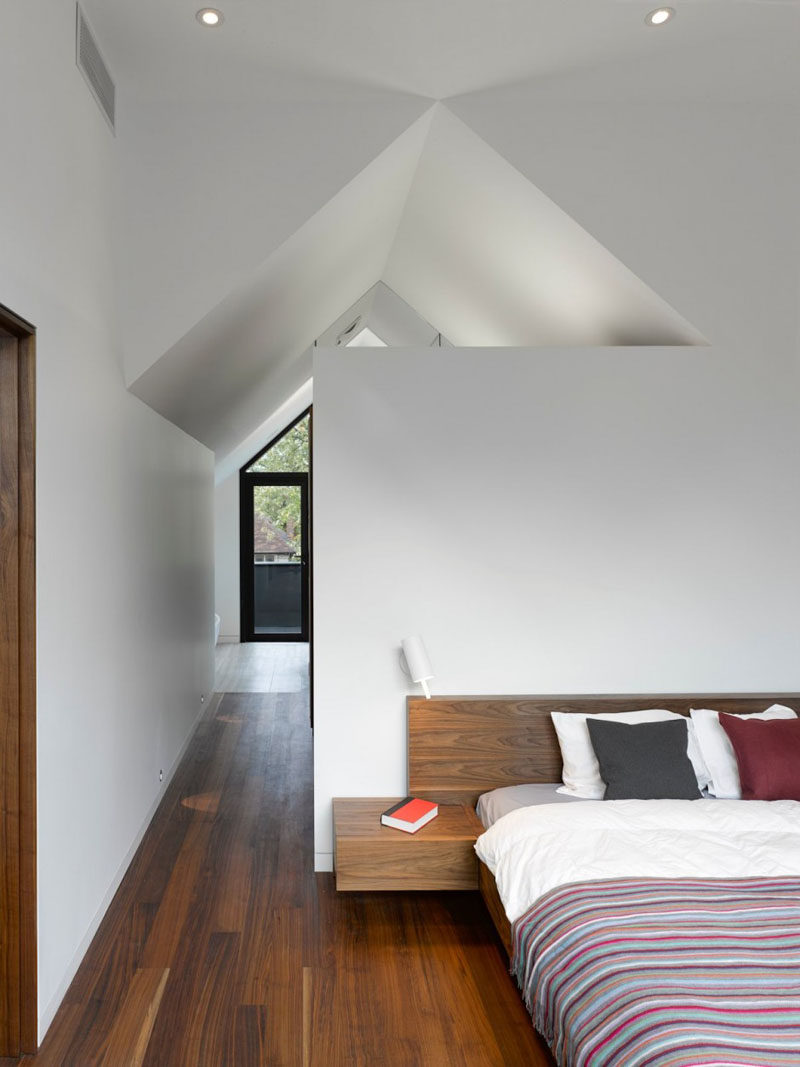 In this modern bedroom, high white ceilings create a sense of openness, while wood floors and a wood bed frame add a sense of warmth to the room. #ModernBedroom #BedroomDesign