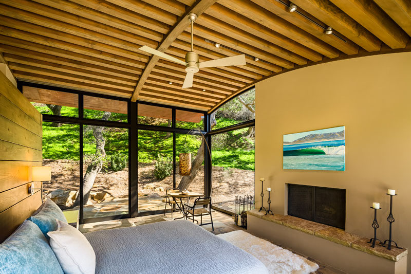 In this master suite, a curved ceiling makes the room feel large and bright, while a built-in fireplace with a Cherokee flagstone hearth, keeps the room feeling cozy on a cold night. #Bedroom #CurvedCeiling #Fireplace