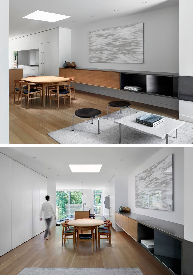 In this modern house, a built-in sideboard lines the wall, while white oak has been used for the wood flooring. A skylight that travels through all of the floors of the home, ends above the dining table, replacing the customary chandelier. #DiningRoom #Skylight #Sideboard