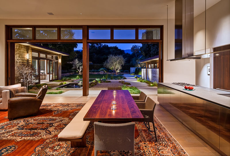 This dining area has a custom designed wood table with chairs and a bench. #DiningTable