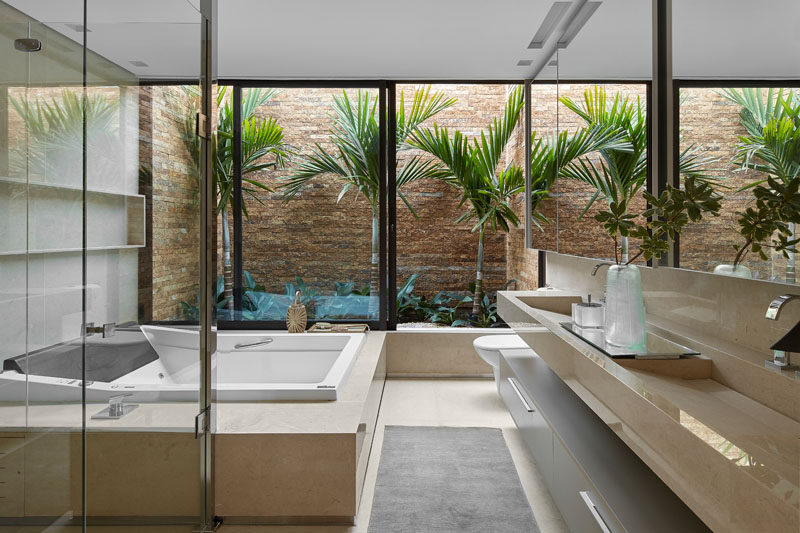 This modern bathroom has a private garden that helps to creates an almost tropical feeling. #ModernBathroom #Garden