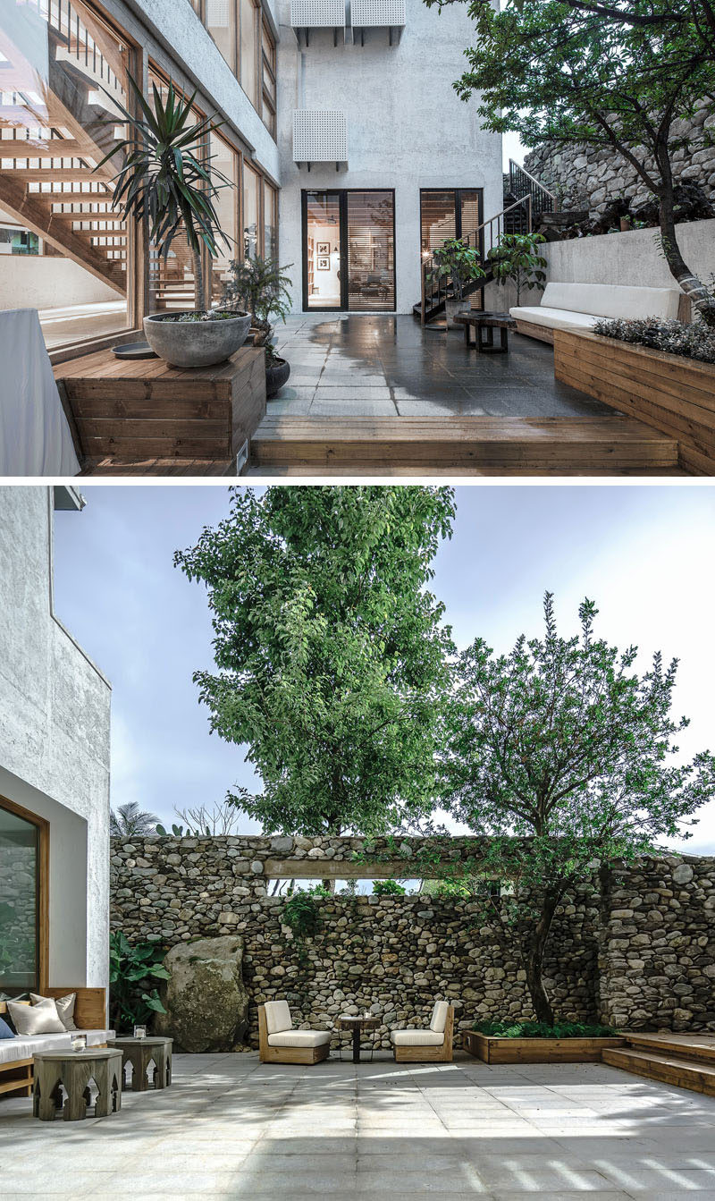 This modern hotel in China has outdoor spaces with wood planters, outdoor couches and a high stone wall. #OutdoorSpace #HotelDesign