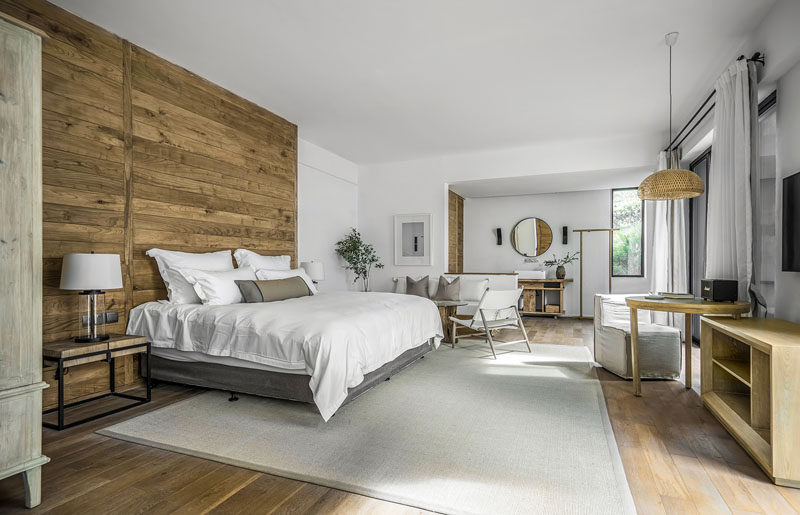 A wood accent wall gives this modern hotel room a unique look and provides the bed with a headboard. #ModernHotel #HotelRoom #WoodAccentWall