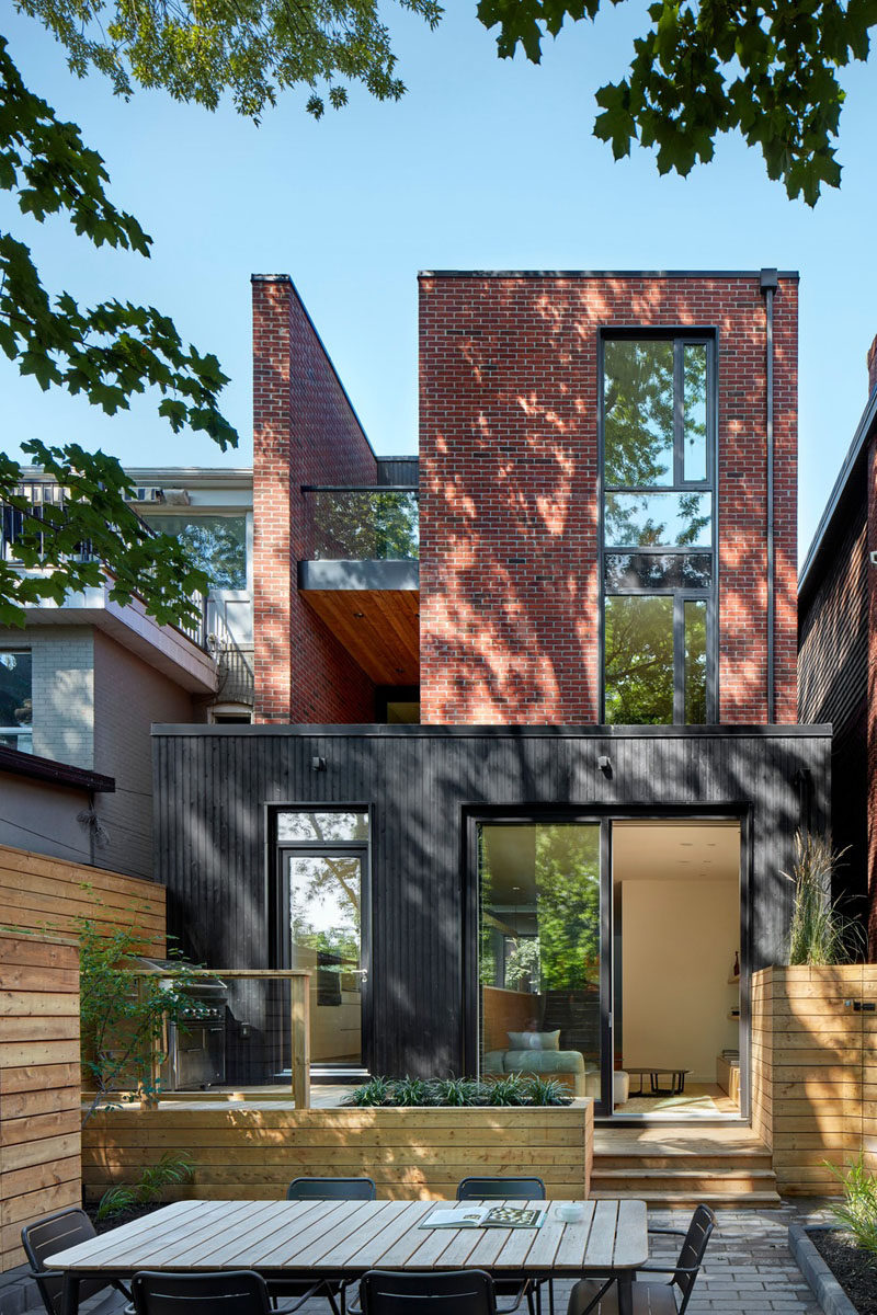 Accessed through the door in the kitchen or from the lower living room, the backyard of this modern house is made up of different levels that house a bbq, planters and an outdoor dining area. #Backyard #Landscaping #OutdoorDining