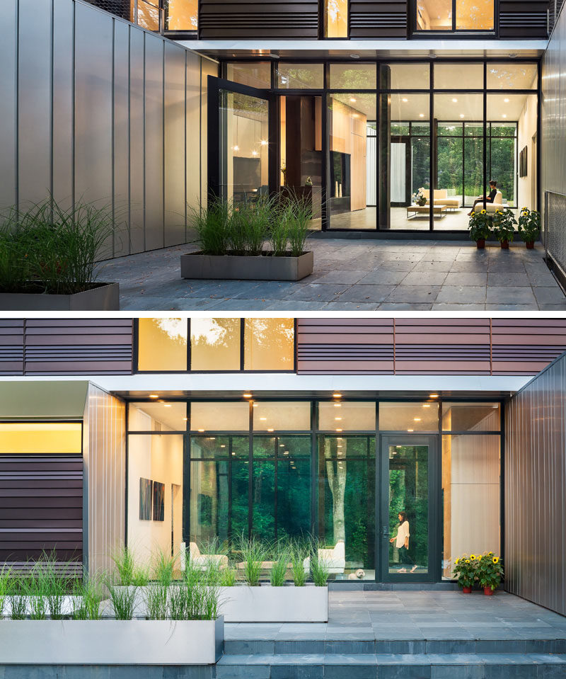 This modern house has a glass front door and matching windows are positioned between the various volumes of the house and welcomes you to a small sitting area. #FrontDoor #Windows