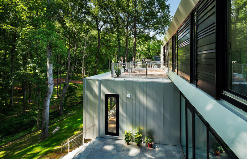 The upstairs of this modern house has access to a small outdoor area that sits on the roof of the lower floor of the home. #OutdoorArea