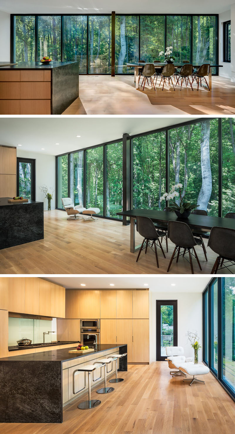  A wall of windows creates a natural backdrop for this large multi-use room. In the kitchen, light wood cabinets have been contemporary with dark stone countertops for a contemporary look. #Kitchen #KitchenDesign #DiningRoom