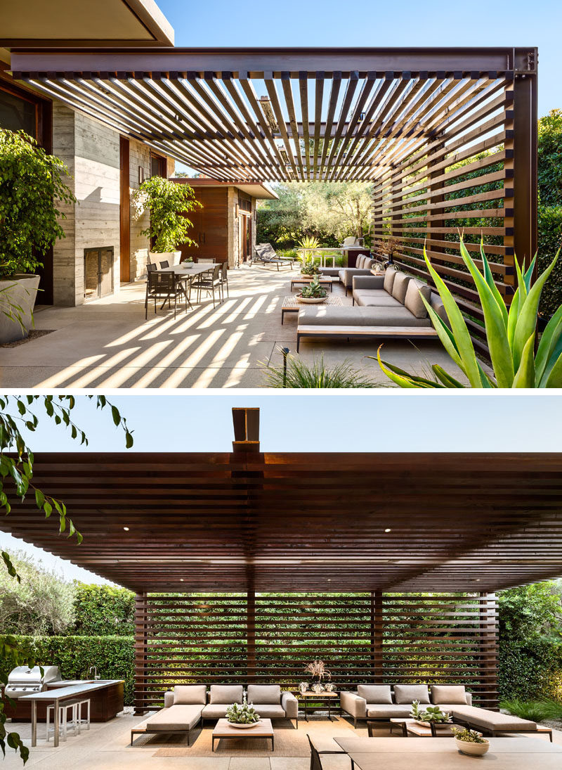 This modern house has an outdoor entertaining area with a wood and steel pergola, a fireplace and lounge area, as well as an outdoor kitchen with a bbq and dining table. #ModernPergola #OutdoorLounge #OutdoorKitchen