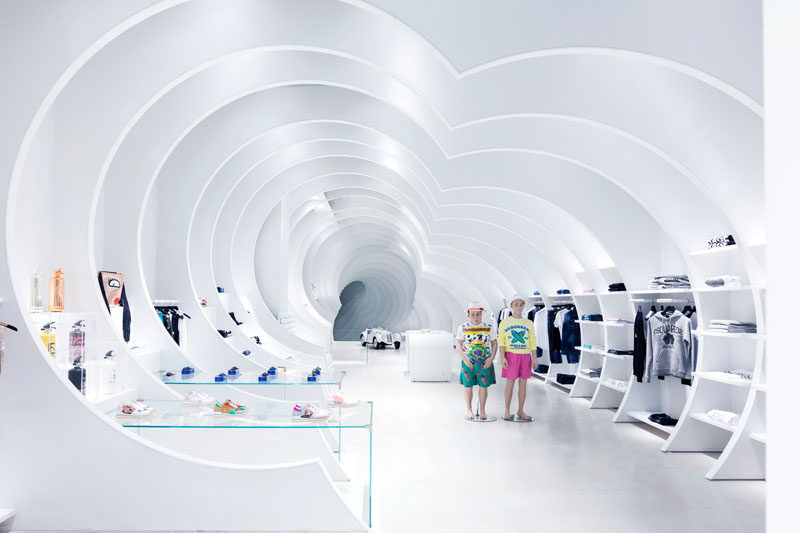 This modern white retail store has 24 white panels that have been placed throughout the length of the store to create a tunnel-like atmosphere. #RetailDesign #RetailStore #InteriorDesign