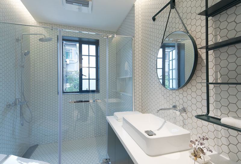  In this modern bathroom, white hexagonal tiles have been used to keep it bright, while black accents create contrast. #WhiteBathroom #ModernBathroom