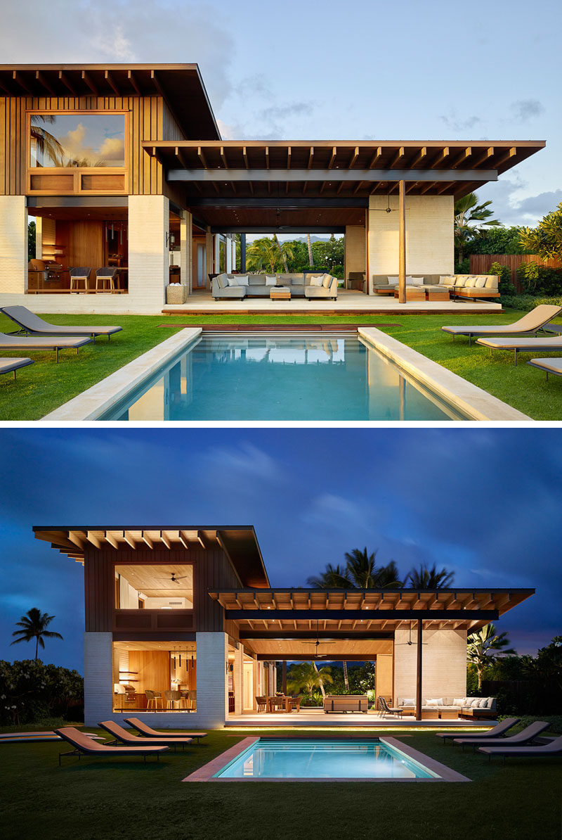 This modern beach house in Hawaii has a swimming pool surrounded by grass and sun-loungers. #SwimmingPool #ModernBeachHouse